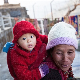 Женщина народности Монпа с ребенком на большом буддийском фестивале