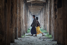Мьянма. Основый старого тикового моста образуют причудливый тунель из столбов под которыми иногда ходят местные жители. Интересно что юбки здесь носят не только женщины. но и мужчины.jpg
